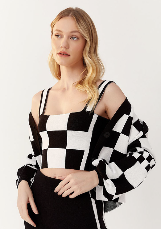 A blonde model is wearing a black and white checkered knit set.