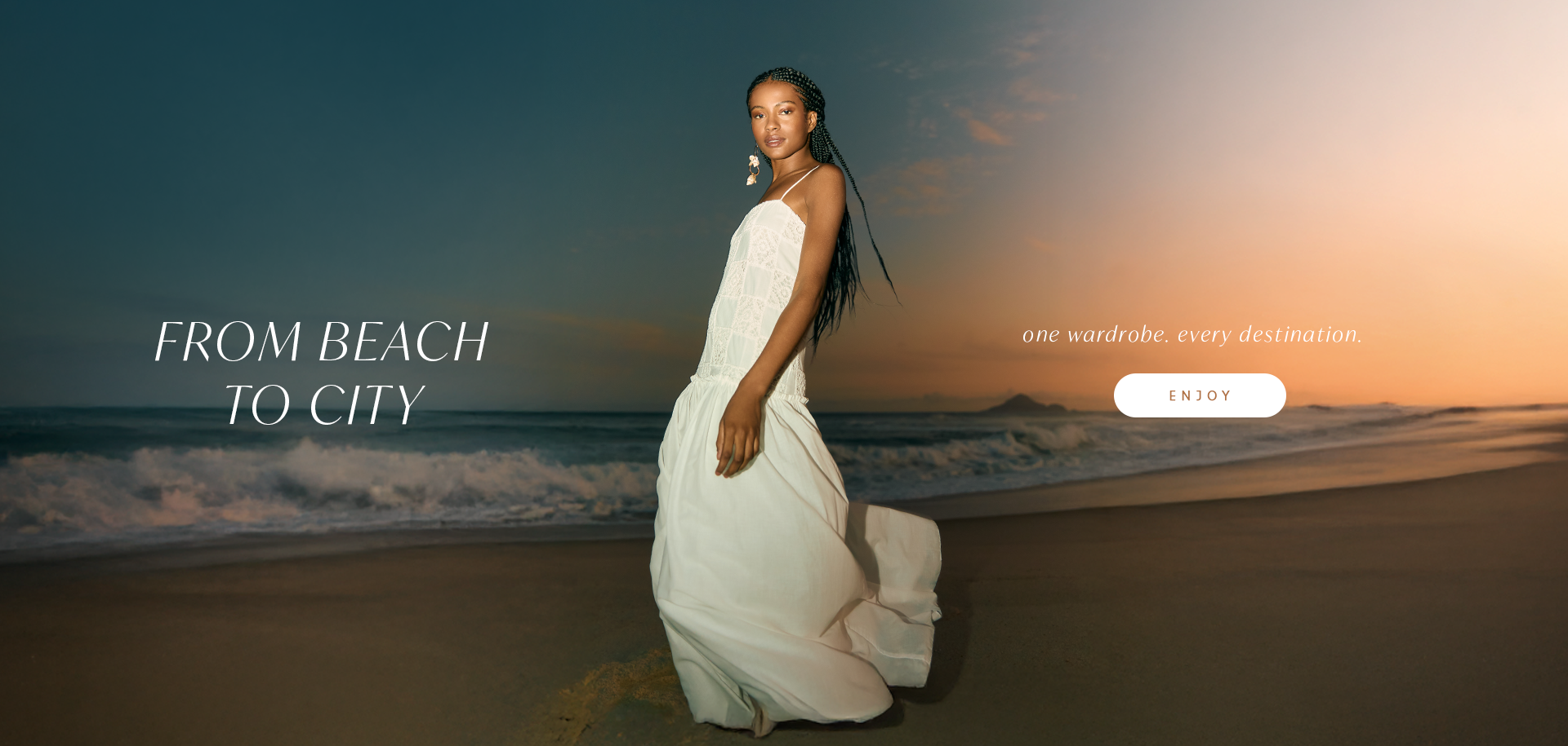 A woman walking along a beach at sunset, wearing a white dress. The text 'FROM BEACH TO CITY' is at the top, with the tagline 'one wardrobe. every destination.' and an 'ENJOY' button.